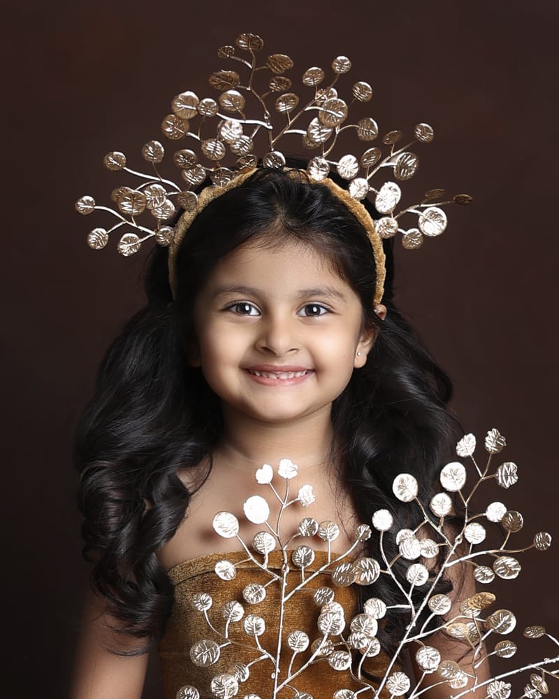Child posing with whimsical studio accessories