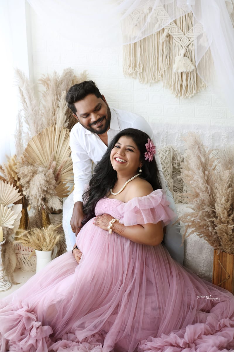 Mother cradling baby bump in studio portrait