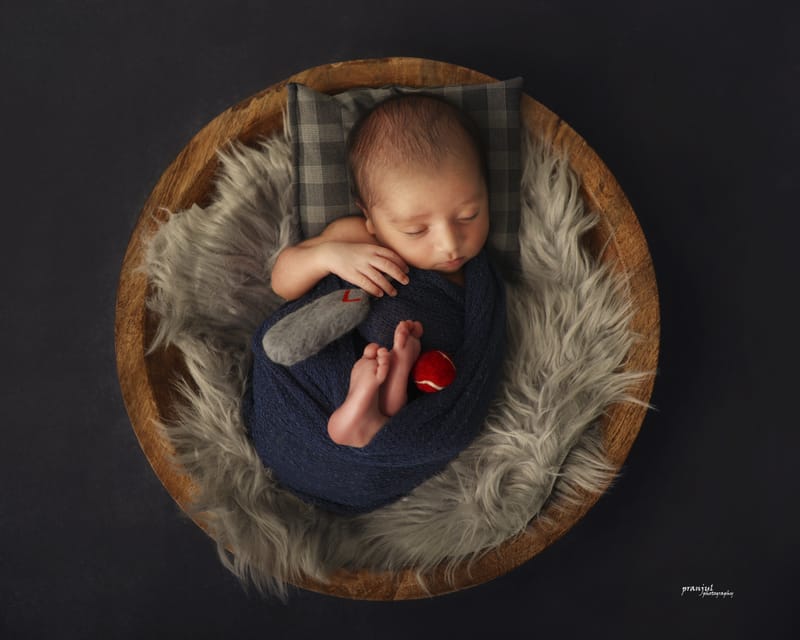 Newborn baby in a cozy studio prop