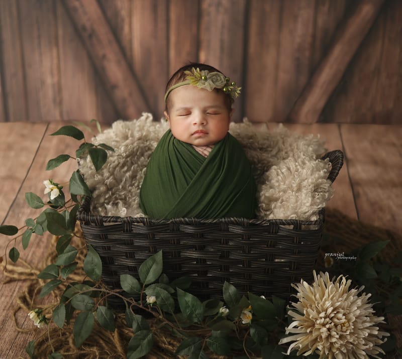 Peaceful newborn in a bucket prop setup